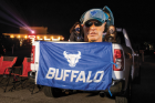 WEDNESDAY, NOV. 4, 7:47 P.M. DRIVE-IN FOOTBALL Fans tailgate with an outsize cutout of Coach Lance Leipold, while watching the Bulls play Northern Illinois at the Transit Drive-in. The nighttime spectacle was arranged to collectively—and safely—view the first game of a season delayed by the pandemic. The Bulls won 49-30. PHOTO BY MEREDITH FORREST KULWICKI 