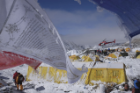 Buddhist prayer flags frame a rescue helicopter taking off from Base Camp. Photo: Roberto Schmidt/AFP/Getty Images