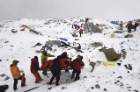 Rescuers use a makeshift stretcher to carry an injured person out of Base Camp. Photo: Roberto Schmidt/AFP/Getty Images