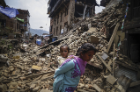 A Nepalese woman carrying her child walks past collapsed buildings in Kathmandu from a second major earthquake (magnitude 7.3) on May 12. Photo: Sunil Pradhan/Anadolu Agency/Getty Images