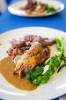 The entree: breast of Cornish hen and pan-seared culotte duo served with an apricot beer sauce and accompanied by a warm wild rice and fava bean salad, broccoli rabe and herb vinaigrette.