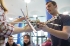 Students prepare their entry in the popular egg drop competition. The idea is to build a contraption that will enable an egg to survive a fall from the third floor of the Student Union to the lobby below.