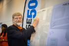 Ed Goit (MS ’69, BA ’67), a CSE grad from the department’s early years, adds his name to a message board at the alumni symposium in September. Photo: Douglas Levere