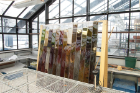 Nicole Clouston incubating columns in UB greenhouse • 2016 • Using soil as its medium, this project involves filling a series of acrylic prisms with mud and nutrients. When exposed to light, microbial life in the mud will flourish in varied layers, creating vibrantly colored bands throughout the sculpture.