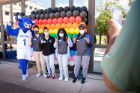 Diversity Advocates from the IDC taking a picture with UB mascot Victor E. Bull in front of a display of rainbow baloons. Photographer: Meredith Forrest Kulwicki