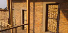 Afternoon sunlight is cast on the brick walls outside the offices and on the steel and wood-screen doors.