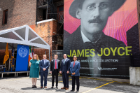 President Tripathi and UB Libraries' Evviva Weinraub Lajoie and James Maynard stand with Consul General of Ireland in New York Ciarán Madden and New York State Senator Tim Kennedy in front of the new 36-foot-tall mural of renowned author and poet James Joyce in June 2021 in downtown Buffalo. The event took place outside of the LoTempio P.C. Law Group building where the mural is installed. Photographer: Meredith Forrest Kulwicki