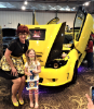 Lisa Monpere-Cruz trophy picture in front of custom car. 