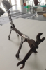 steel sculpture using wrenches that looks like a dog with a bone. 