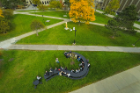 University Communications' drone camera captures Matthew Hume's class seated at "Why?" The 40-by-20 question mark-shaped picnic table can seat about 60 and serves as a place to meet and question things, according to artist Michael Beitz. "What could be more important at the present moment than to be critical in looking for points of unity and gathering?" Beitz says.