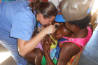 Nadia Telt, a fellow in pediatrics-emergency medicine, examines a child's ears.