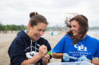 Engineering professor Lauren Sassoubre (left) collects water samples with Hailie Suk, an environmental engineering major. They are investigating potential pollution sources at Woodlawn Beach on Lake Erie. Photo: Onion Studio