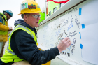 A worker signs the final beam at the topping out ceremony in March for the new home for the Jacobs School of Medicine and Biomedical Sciences on the Buffalo Niagara Medical Campus.