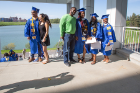 Graduates pose for photos behind the Center for the Arts, with picturesque Lake LaSalle in the background.