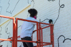 Staff from the Albright-Knox Art Gallery painted the brown brick wall of the former Houdaille Industries building white before Shantell Martin arrived to paint her signature black lines. Photo: Bruce Jackson 