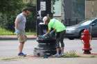 Robert Mayer Jr., director of government relations, and Tess Morrissey, director of community relations, joined volunteers giving light posts along Main Street in University Heights a new coat of paint. Photo: Darren Cotton