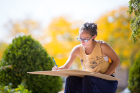 A student takes advantage of the nice weather to sketch outside.