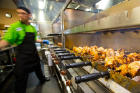 A worker tends to rotisserie chickens at a food preparation station in Crossroads Culinary Center in the Ellicott Complex. Photo: Meredith Forrest Kulwicki