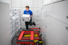 Colin Sleight steps lively as he stacks boxes in a large file storage room.