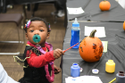 Daionna Stephens, age 1, creates pumpkin art.
