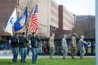 The UB Police Color Guard — Officer Chris Fisher (Army), Officer John Sindoni (USMC) and Officer Dale Zulawski — stands at attention as student cadets of the local ROTC Color Guard prepare for the flag ceremony at Flint Loop in front of Capen Hall.
