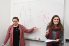 Second-year medical students Teigan Ruster (left) and Cynthia Alvarez draw heart diagrams as part of a lesson on the human heart. 