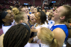 Bulls head coach Felisha Legette-Jack (center) is surrounded by jubilant players after defeating Florida State, 86-65, on its home court.