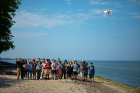 Professors, students and teachers wave at the drone as it takes their photo.