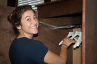First-year student Jenna Betz adds hangers to a closet at the Kevin Guest House.
