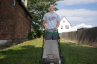 First-year student Thomas Barbaccia mows the grass at the Fruit Belt Coalition on Mulberry Street.