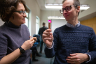Judges Ekin Atilla-Gokcumen and Timothy Cook, both assistant professors of chemistry, inspect a crystal submitted in the "coolest crystal" category. Cook brought a flashlight to the judging. Photo: Douglas Levere