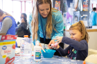 Sidney Finster (left) helps Hannah Bartz create some "slime" at one of the fun activity tables during the event.