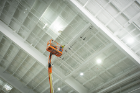 A worker installs some of the 1,300 linear feet of motorized athletic divider netting.