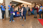 An attendee learns about a remote-controlled mini-robot operated by a volunteer with the Coder School Buffalo.
