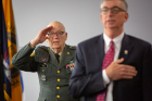 Efner 'Lucky' Davis salutes during the Pledge of Allegiance. At Davis' right is A. Scott Weber, vice president for student life. Davis, a World War II veteran, made a significant gift to UB several years ago to support creation of a student lounge in the Office of Veterans Services.