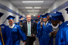 Bill Regan walks between lines of graduates as they prepare to enter the 2019 College of Arts and Sciences' commencement ceremony in Alumni Arena. Photo: Meredith Forrest Kulwicki