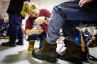 Anna Hargrave, a pre-medical student who volunteers with UB HEALS, helps lace up a client's new boots.