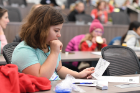 Izabelle Tucholski, a sixth-grader from Transit Middle School, looks over her event passport. The scouts received stickers for their passports at each of the morning's events. 