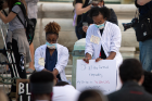 Latrice Johnson (left) and Ashley Jeanlus (right) kneel in Niagara Square.