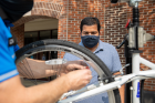 Gaurav Vishwakarma, a PhD candidate in chemical and biological engineering, watches as Scott Bixby tunes up his bike.