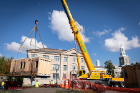 A crane lifts the GRoW Home from its temporary home behind Hayes Hall and Wende Hall on the South Campus.