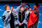Justice Ruth Bader Ginsburg is hooded by President Satish K. Tripathi and Merryl H. Tisch, chairman of the SUNY Board of Trustees. Photo: Douglas Levere