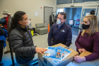 From left: UB dental student Philip Sales discusses the masks with Michael O'Hara, Buffalo City Mission manager of major gifts, and Heather Mattiuzzo.