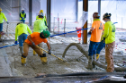 Other workers spread the concrete as it’s pumped into the space.