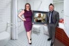 RHM Innovations Inc. team members Courtney Burris and Brandon Davis. Burris’ father, Robert Burns, is pictured in the framed photo. RHM developed a shower chair accessory that promotes independence while bathing, aiding in injury prevention within the aging community.