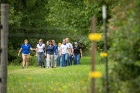 Deanna Hostler takes students on a discovery walk around the farm to see, hear and smell the farm's pear trees, vegetable plots, hops, chickens and cows.