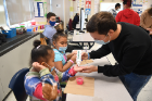 Medical student Anthony Snyder helps (from left) third-grader Naila Antonetti and her sister, fourth-grader Milana Antonetti, both students at School 27.