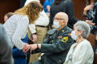 An attendee greets World War II veteran Efner "Lucky" Davis and his wife. Davis served in the Pacific Theater during World War II, specifically in Guadalcanal, Bougainville and Louzan, and took part in the occupation of Sendi, Japan, in January 1946. He served an additional four years in the reserves.