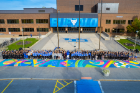 UB female student-athletes pose together by the new Title IX mural.