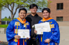 Two ALANA graduates show off their certificates of achievement.